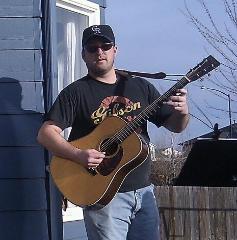 Nick with acoustic guitar outside